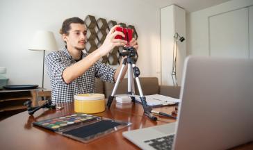 Guy using a phone on a tripod to record a video